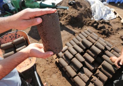 مواطنون يصنعون قوالب من لب الزيتون والذي يستخدم كمصدر للطاقة في إحدى معاصر خان يونس