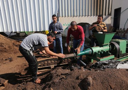 مواطنون يصنعون قوالب من لب الزيتون والذي يستخدم كمصدر للطاقة في إحدى معاصر خان يونس