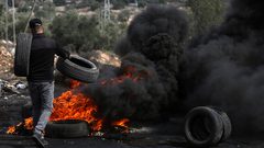 متظاهرون يحرقون الإطارات أثناء المواجهات مع قوات الاحتلال الإسرائيلي خلال مسيرة كفر قدوم السلمية الأسبوعية.
