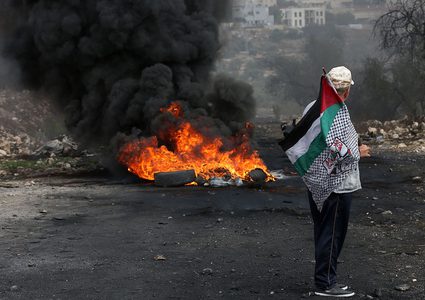 متظاهرون يحرقون الإطارات أثناء المواجهات مع قوات الاحتلال الإسرائيلي خلال مسيرة كفر قدوم السلمية الأسبوعية.