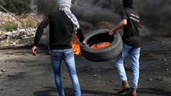 متظاهرون يحرقون الإطارات أثناء المواجهات مع قوات الاحتلال الإسرائيلي خلال مسيرة كفر قدوم السلمية الأسبوعية.