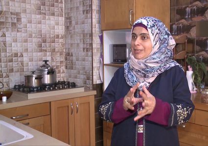 سيدة فلسطينية تحضر منتجات غذائية من الورد