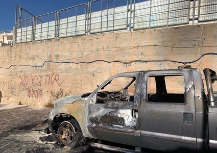 مستوطنون يحرقون مركبة ويعطبون أخريات ويخطون شعارات عنصرية