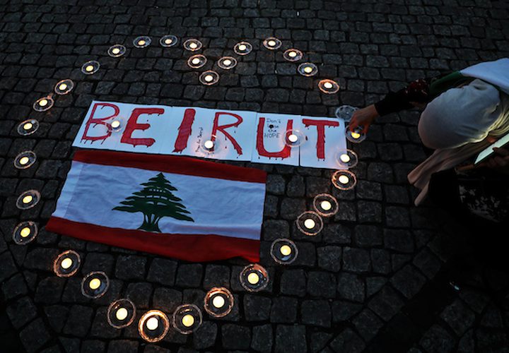 الفلسطينيون والأجانب يضيئون الشموع للتعبير عن تعازيهم للشعب اللبناني أثناء رفع العلم الوطني اللبناني ، في برلين ، ألمانيا ، في 8 أغسطس 2020.