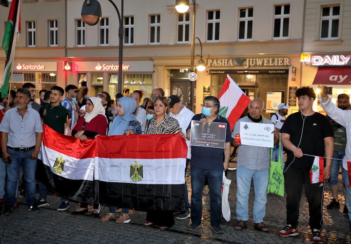 الفلسطينيون والأجانب يضيئون الشموع للتعبير عن تعازيهم للشعب اللبناني أثناء رفع العلم الوطني اللبناني ، في برلين ، ألمانيا ، في 8 أغسطس 2020.