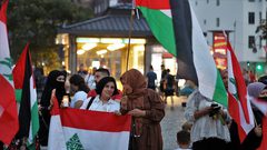 الفلسطينيون والأجانب يضيئون الشموع للتعبير عن تعازيهم للشعب اللبناني أثناء رفع العلم الوطني اللبناني ، في برلين ، ألمانيا ، في 8 أغسطس 2020.