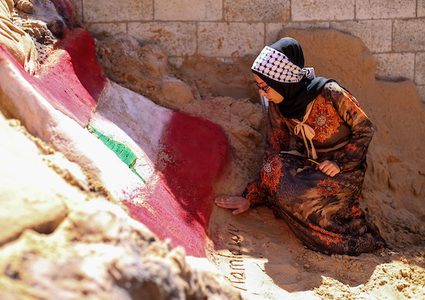 فنانة فلسطينية من غزة ترسم علم لبنان على تمثال رملي