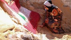 الفنانة الفلسطينية رنا الرملاوي ، 25 سنة ، ترسم علم لبنان على تمثال رملي في منزلها ، تضامناً مع اللبنانيين ، في مدينة غزة.