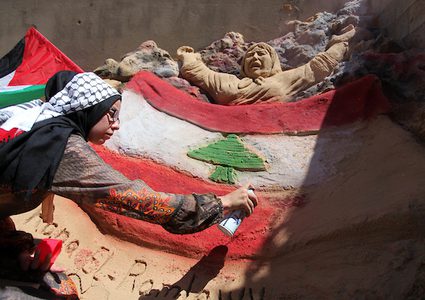 فنانة فلسطينية من غزة ترسم علم لبنان على تمثال رملي
