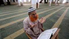 إمام المسجد الفلسطيني يصلي في مسجد يخلو من المصلين، بعد إغلاقه كإجراء احترازي من انتشار فيروس كورونا  خلال إغلاق لمدة 48 ساعة