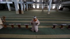 إمام المسجد الفلسطيني يصلي في مسجد يخلو من المصلين، بعد إغلاقه كإجراء احترازي من انتشار فيروس كورونا  خلال إغلاق لمدة 48 ساعة