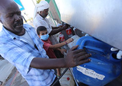 فلسطينيون يملأون الزجاجات من صنبور عام خلال فترة الاغلاق في غزة