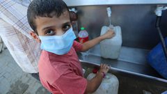 فلسطينيون يملأون الزجاجات من صنبور عام خلال فترة الاغلاق في غزة