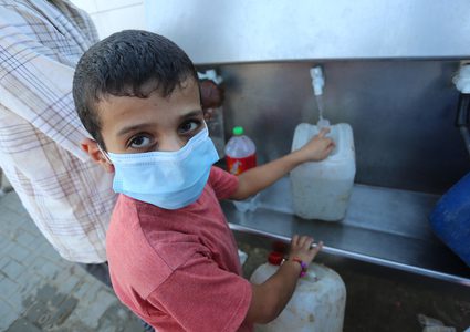 فلسطينيون يملأون الزجاجات من صنبور عام خلال فترة الاغلاق في غزة