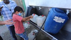 فلسطينيون يملأون الزجاجات من صنبور عام خلال فترة الاغلاق في غزة