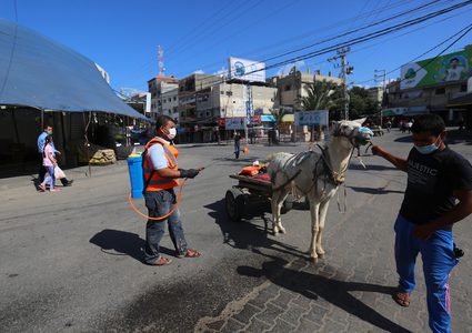 عمال فلسطينيون يعقمون الشوارع خلال الإغلاق المفروض في قطاع غزة