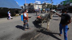 عمال فلسطينيون يعقمون الشوارع، خلال الإغلاق المفروض قطاع غزة