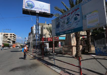 عمال فلسطينيون يعقمون الشوارع خلال الإغلاق المفروض في قطاع غزة