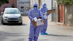 ممرضون من الأونروا  يوزعون العلاج الشهري للأمراض المزمنة في دير البلح خلال حظر التجوال المفروض بسبب جائحة كورونا