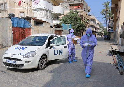 ممرضون من الأونروا  يوزعون العلاج الشهري للأمراض المزمنة في دير البلح خلال حظر التجوال المفروض بسبب جائحة كورونا