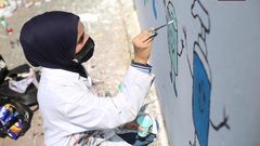 فنانون فلسطينيون يرسمون جدارية للتوعية من فيروس كورونا في دير البلح
