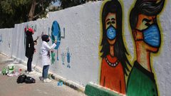 فنانون فلسطينيون يرسمون جدارية للتوعية من فيروس كورونا في دير البلح