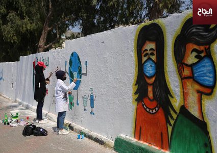 فنانون يرسمون جدارية للتوعية من فيروس كورونا في دير البلح