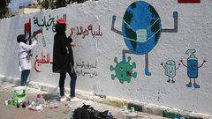 فنانون فلسطينيون يرسمون جدارية للتوعية من فيروس كورونا في دير البلح