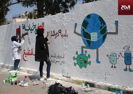 فنانون فلسطينيون يرسمون جدارية للتوعية من فيروس كورونا في دير البلح