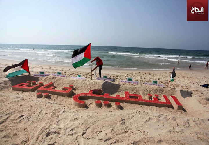 فنان فلسطيني ينحت "التطبيع خيانة" على رمال شاطىء غزة