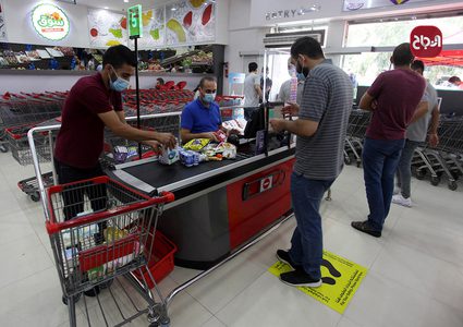 مواطنون يلتزمون بارتداء الكمامات أثناء التسوق بغزة