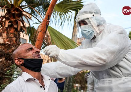 أطباء يرتدون الملابس الوقاية خلال أخذ عينات فحص كورونا