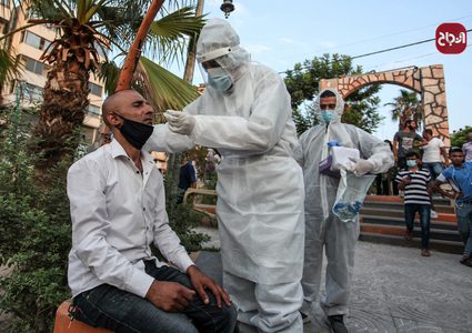 أطباء يرتدون الملابس الوقاية خلال أخذ عينات فحص كورونا في المرافق العامة بغزة