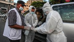أطباء يرتدون الملابس الوقاية خلال أخذ عينات فحص كورونا في المرافق العامة بغزة