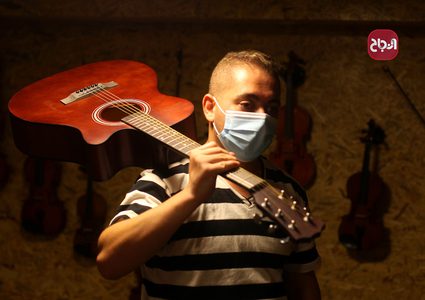 مواطنون يعرضون الآت موسيقية في متجرهم في مدينة غزة والذي أعيد فتحة جزئيًا بسبب أزمة كورونا