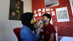 الرسامة الفلسطينية رنين الزريعي ترسم كمامات على وجوه الأطفال في ظل تفشي كورونا