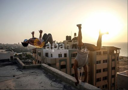 لاعبو باركور يرتدون أقنعة ويظهرون مهاراتهم على سطح مبنى بغزة