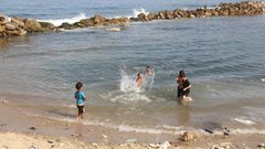 أطفال يسبحون على شاطىء البحر بمخيم الشاطئ غرب غزة