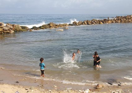 أطفال يسبحون على شاطىء البحر غرب غزة