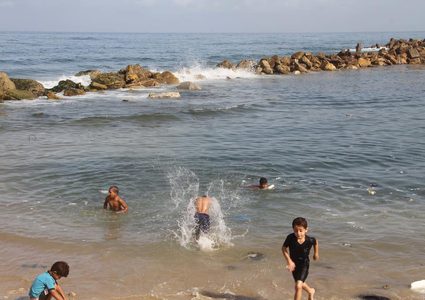 أطفال يسبحون على شاطىء البحر بمخيم الشاطئ غرب غزة