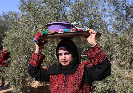 إمرأة فلسطينية تشارك في حفل افتتاح موسم الزيتون في بلدة خزاعة ، شرق خان يونس جنوب قطاع غزة