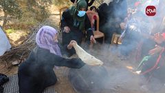 سيدات يصنعن الخبز خلال موسم قطف الزيتون بغزة