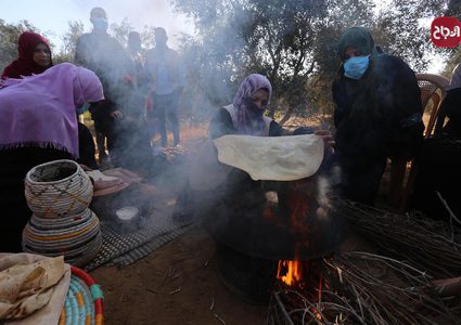 سيدات يصنعن الخبز خلال موسم قطف الزيتون بغزة