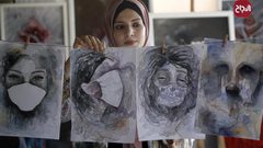 الفنانة الفلسطينية خلود الدسوقي تعلق لوحاتها في منزلها بخان يونس جنوب قطاع غزة