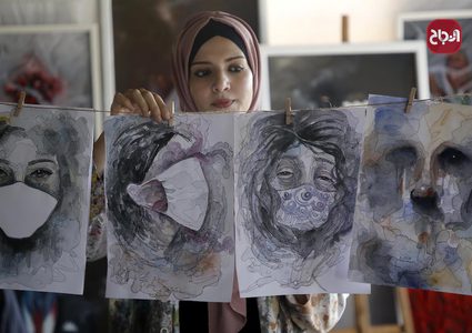 الفنانة الفلسطينية خلود الدسوقي تعلق لوحاتها في منزلها بخان يونس جنوب قطاع غزة