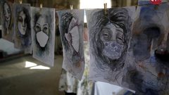 الفنانة الفلسطينية خلود الدسوقي تعلق لوحاتها في منزلها بخان يونس جنوب قطاع غزة