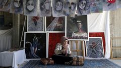 الفنانة الفلسطينية خلود الدسوقي تعلق لوحاتها في منزلها بخان يونس جنوب قطاع غزة
