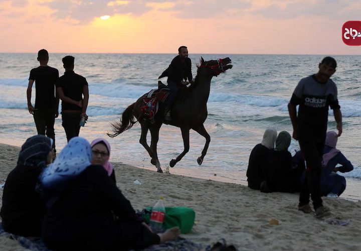 مواطنون يستمتعون على شاطىء دير البلح وسط قطاع غزة