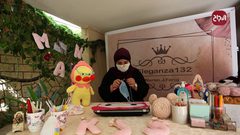 الفنانة الفلسطينية نوران فرج تصنع أقنعة واقية من الكروشيه في منزلها بغزة