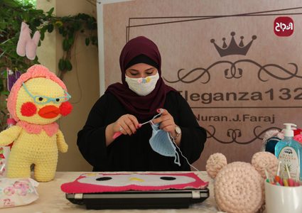الفنانة الفلسطينية نوران فرج تصنع أقنعة واقية من الكروشيه في منزلها بغزة